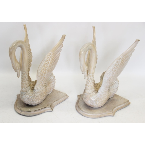 626 - A pair of carved limed wooden swan figures, 20th century, modelled wings raised and mounted upon a s... 