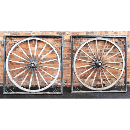 864 - A pair of rustic cartwheel gates, each constructed with a fifteen spoke wooden cartwheel mounted wit... 