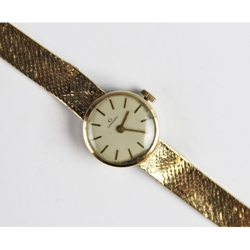 133 - A lady's vintage 9ct gold Garrard wristwatch, the round cream dial with baton markers, set to a plai... 