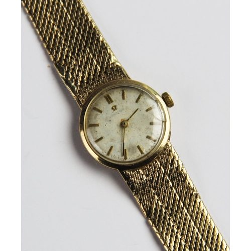 134 - A lady's vintage 9ct gold Omega wristwatch, the circular silver dial with baton markers set to a pla... 