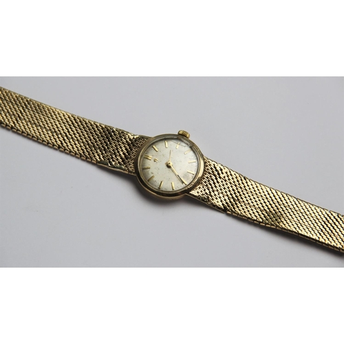 134 - A lady's vintage 9ct gold Omega wristwatch, the circular silver dial with baton markers set to a pla... 