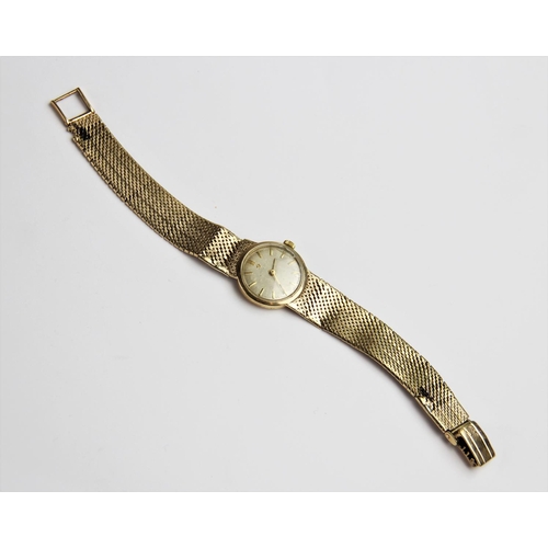 134 - A lady's vintage 9ct gold Omega wristwatch, the circular silver dial with baton markers set to a pla... 