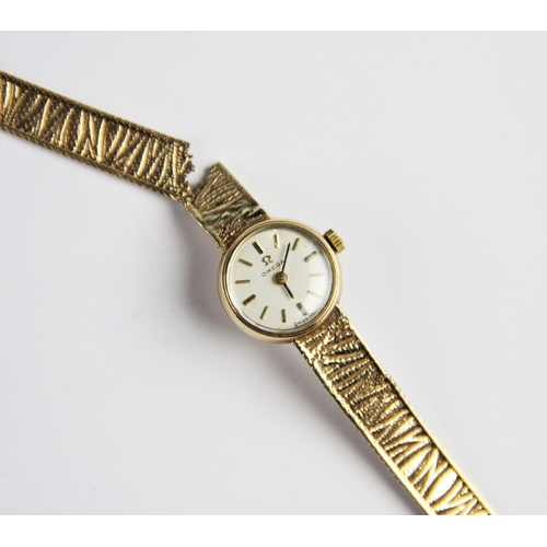 135 - A lady's vintage 9ct gold Omega wristwatch, the cream circular dial with baton markers, set to a pla... 