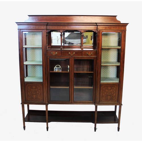 852 - An Edwardian inlaid mahogany inverted breakfront display cabinet, the shaped pediment above a centra... 