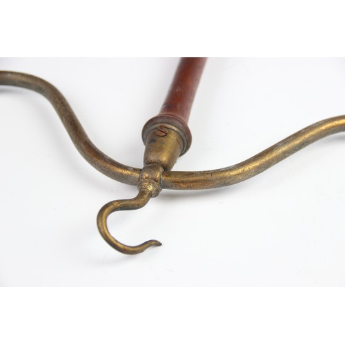 318 - Five Victorian wig and gown hangers, the lacquered brass hooks terminating two arms supported by a t... 