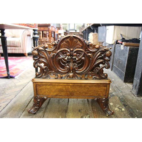 825 - A Victorian figured walnut Canterbury, the outer carved foliate open work dividers flanking a pair o... 