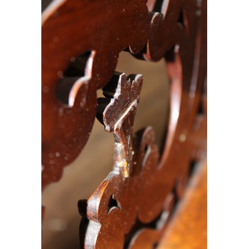 825 - A Victorian figured walnut Canterbury, the outer carved foliate open work dividers flanking a pair o... 