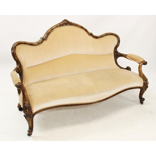 1015 - A Victorian walnut framed settee, the serpentine back carved with ribbon tied detail, above the spru... 