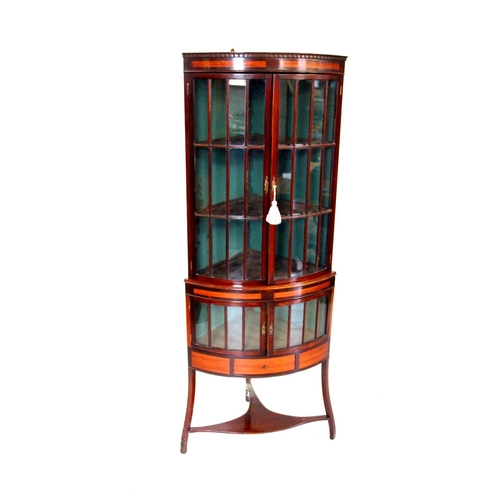 1032 - An Edwardian mahogany bow front free standing corner display cabinet, with an inlaid satinwood friez... 