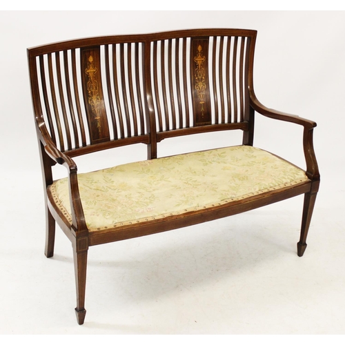 1038 - An Edwardian inlaid mahogany two-seater settee, with a pair of inlaid splats above an upholstered se... 