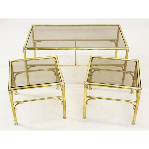 1050 - A mid 20th century gilt metal and smoked glass nest of three tables, the rectangular glass tops supp... 