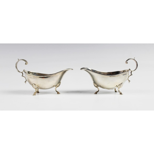 129 - A pair of Edwardian silver sauce boats by Walker and Hall, Chester 1909, each of typical form with s... 