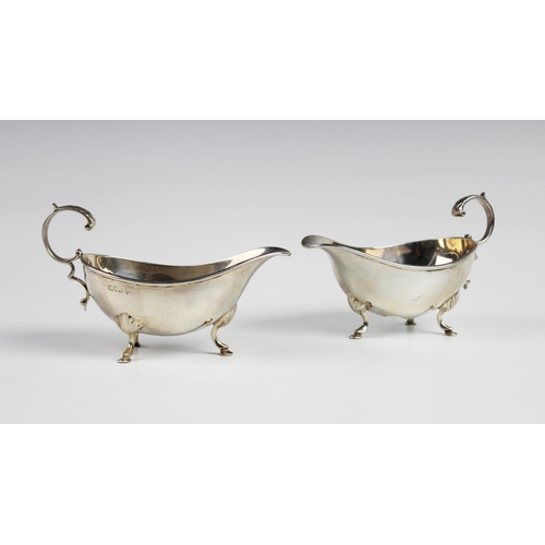 129 - A pair of Edwardian silver sauce boats by Walker and Hall, Chester 1909, each of typical form with s... 