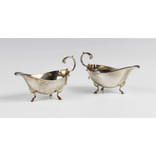 129 - A pair of Edwardian silver sauce boats by Walker and Hall, Chester 1909, each of typical form with s... 