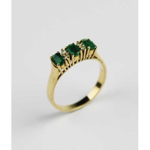 199 - An emerald and diamond ring, comprising three mixed cut oval emeralds each measuring 4.7mm x 3mm, in... 