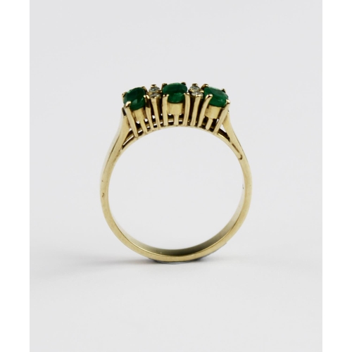 199 - An emerald and diamond ring, comprising three mixed cut oval emeralds each measuring 4.7mm x 3mm, in... 