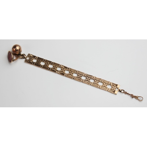 225 - A 9ct gold gate-link bracelet by Charles Daniel Broughton, each panel with pierced scrolling decorat... 