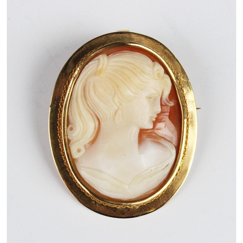 283 - A carved shell cameo brooch pendant, the central carved cameo depicting the profile of a woman, set ... 