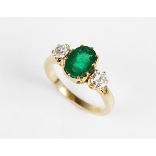 311 - An emerald and diamond 3-stone ring, the central oval mixed cut emerald (measuring 8.5mm x 6.5mm x 5... 