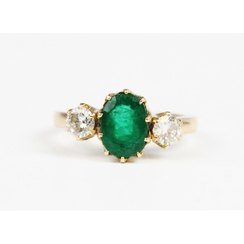 311 - An emerald and diamond 3-stone ring, the central oval mixed cut emerald (measuring 8.5mm x 6.5mm x 5... 