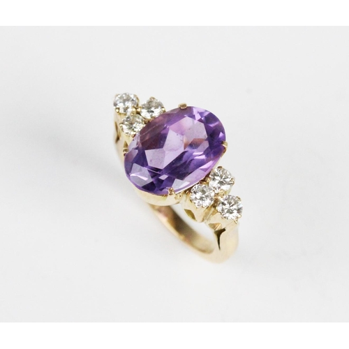 312 - An amethyst and diamond ring, the central oval mixed cut amethyst (measuring 14mm x 10mm), with thre... 