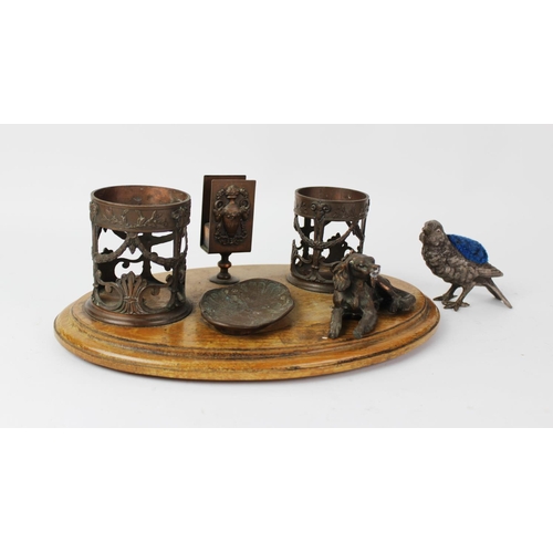 378 - An early 20th century bronzed metal desk tidy, with two open work cylindrical ink pot wells, a vesta... 