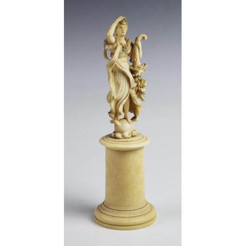 394 - A 19th century carved ivory figure, modelled as a classical lady holding a cornucopia, 22cm high