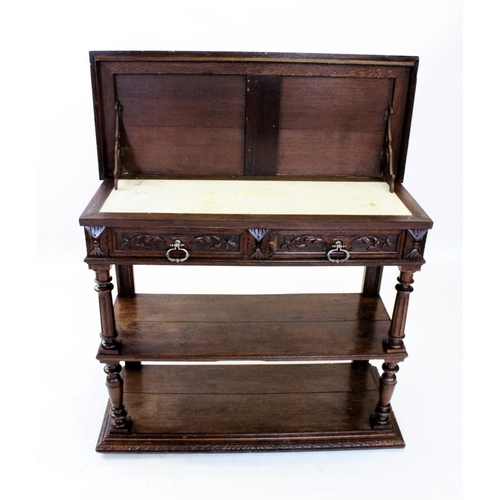 957 - A Victorian oak and marble top buffet, the rectangular hinged top with a carved border enclosing a w... 