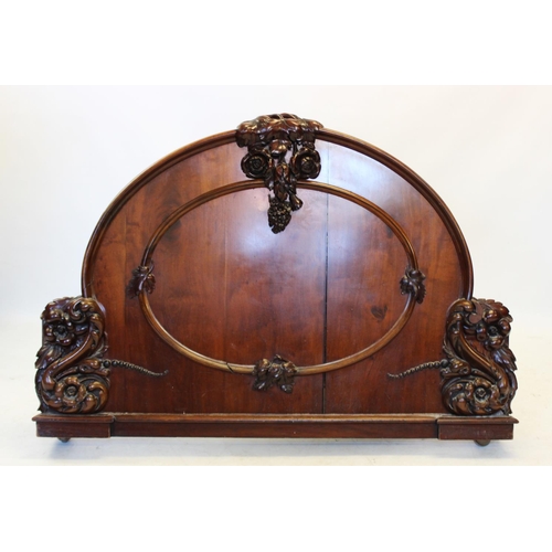 984 - A Victorian mahogany bed, the arched head and foot boards applied with carved fruit and scrolling fo... 