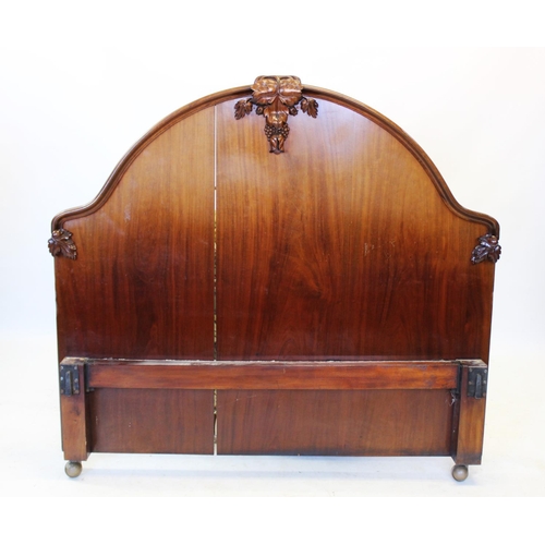 984 - A Victorian mahogany bed, the arched head and foot boards applied with carved fruit and scrolling fo... 