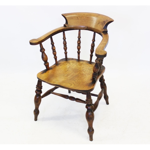 996 - A 19th century elm and beech wood smokers bow elbow chair, the 'C' shaped arm rest with scrolled ter... 