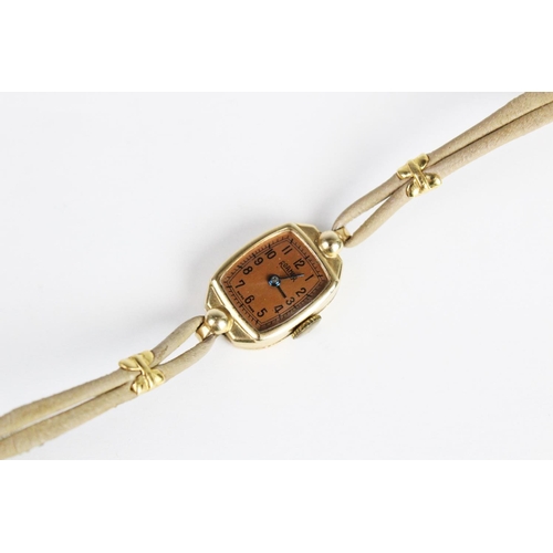 172 - A lady's vintage 14ct gold Roamer wristwatch, the bronze toned tonneau shaped dial with Arabic numer... 