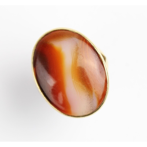 209 - A carnelian set 9ct gold dress ring, the central polished carnelian cabochon measuring 24mm x 18mm, ... 