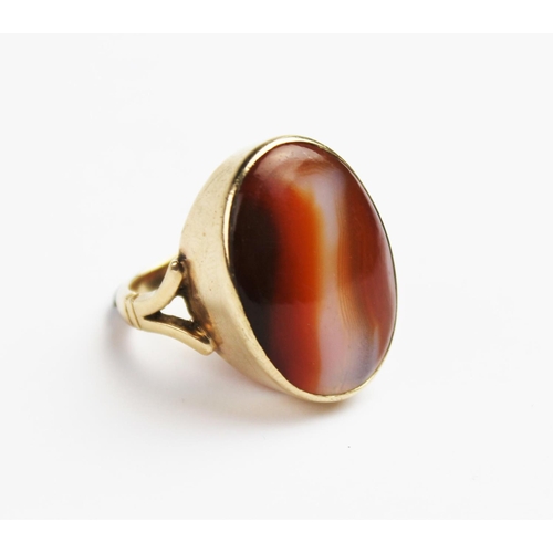 209 - A carnelian set 9ct gold dress ring, the central polished carnelian cabochon measuring 24mm x 18mm, ... 