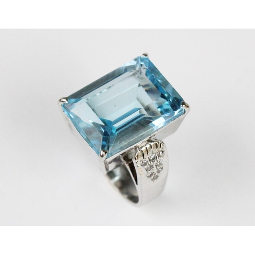 273 - A blue gemstone set dress ring, the central rectangular emerald cut untested gemstone (measuring 20m... 