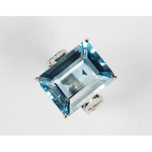 273 - A blue gemstone set dress ring, the central rectangular emerald cut untested gemstone (measuring 20m... 