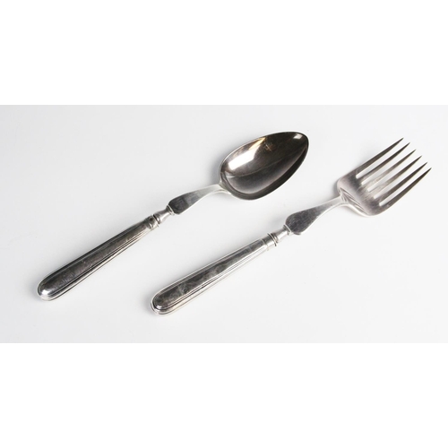 28 - A matched George III silver serving fork and spoon, each with lion crest engraved to weighted handle... 