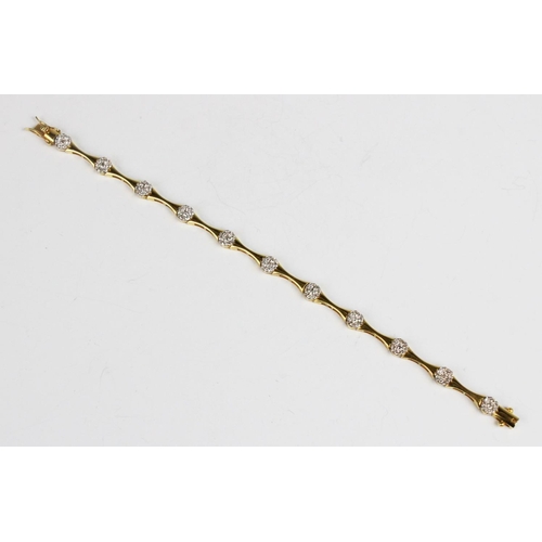 302 - A diamond set line bracelet, comprising ten concave yellow metal links interspersed by eleven circul... 