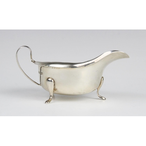 38 - A silver sauce boat by Emile Viner, Sheffield 1963, of typical form with shaped rim and C-shaped han... 