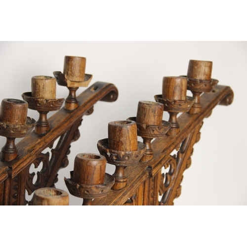 397 - A pair of Puginesque carved wooden six branch ecclesiastical candelabra, late 19th century, of banni... 