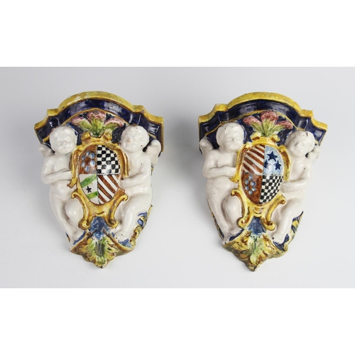 398 - A pair of Portuguese faience ware wall sconces, 19th century, of typical form decorated with cherubs... 