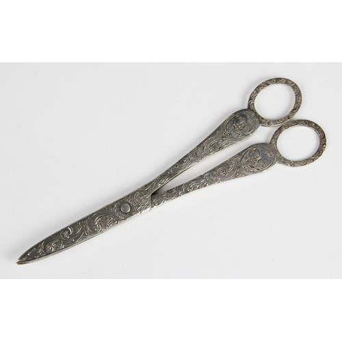 78 - A pair of Victorian silver grape scissors, London 1896 (maker's marks worn), engraved with green man... 