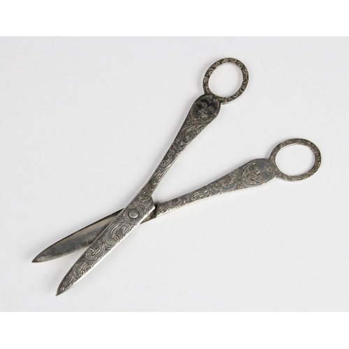 78 - A pair of Victorian silver grape scissors, London 1896 (maker's marks worn), engraved with green man... 