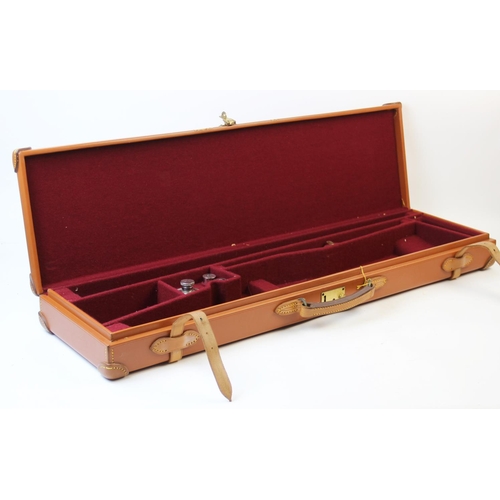 413 - A leather bound 12 bore shotgun case and weather cover, the tan leather case with reinforced corners... 