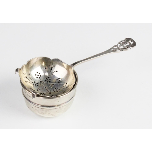 97 - An Arts & Crafts style silver tea strainer and stand by Emile Viner, Sheffield 1935, the bowl with p... 