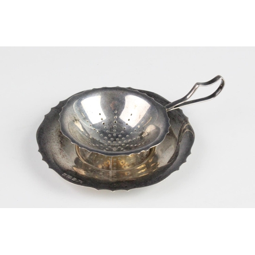 98 - A silver tea strainer and drip bowl by Bishton's Ltd, Birmingham 1970, the bowl with pierced decorat... 