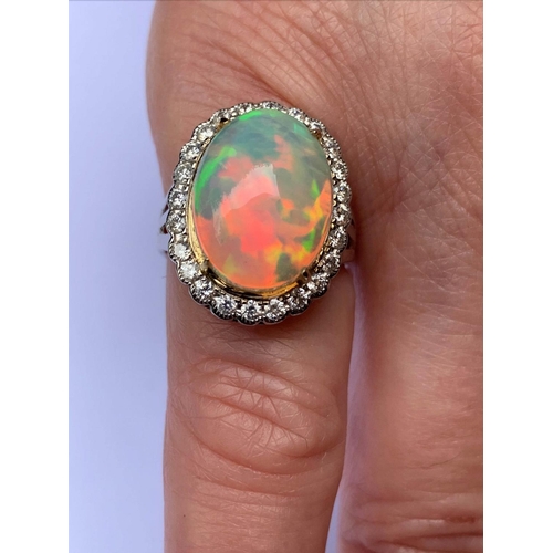 192 - An opal and diamond cluster ring, the central oval natural opal cabochon (measuring 15.2mm x 11.4mm)... 