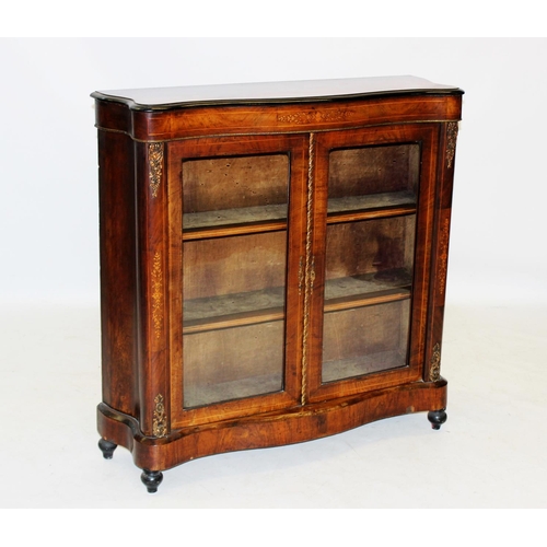 1002 - A late 19th century Louis XV style serpentine vitrine, the moulded top with an ebonised border above... 