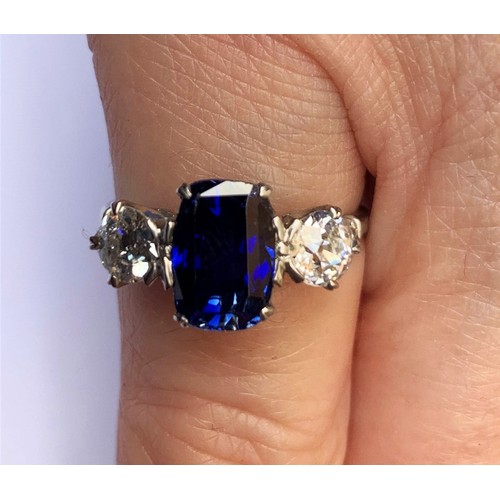 218 - A sapphire and diamond three stone ring, the central cushion cut sapphire (9.2mm x 6.4mm x 5.9mm, ap... 