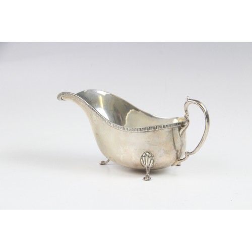 53 - A silver sauce boat by Saunders & Mackenzie, Birmingham 1954, of typical form with gadroon rim and s... 
